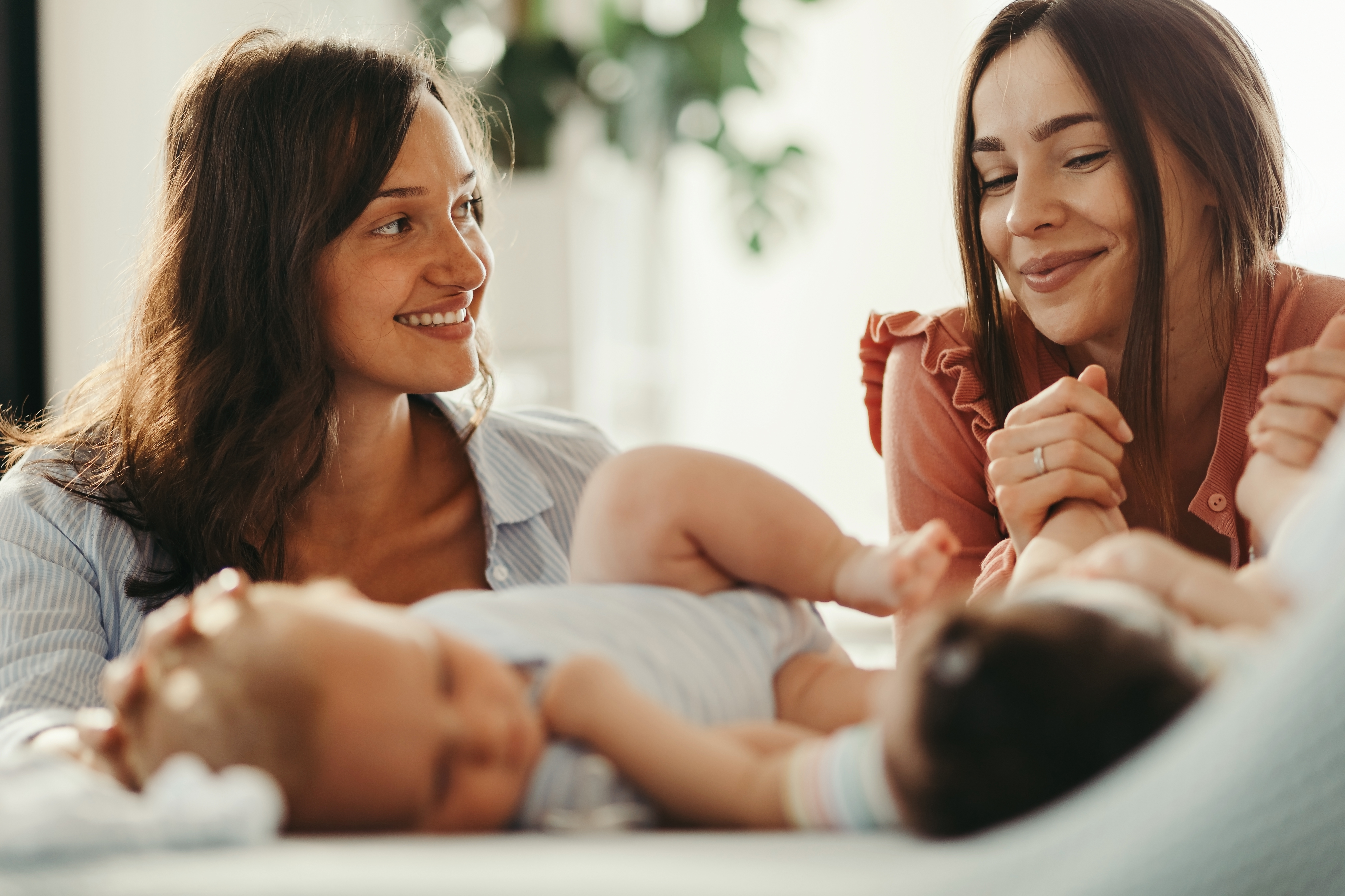 young-happy-mothers-talking-while-spending-time-with-their-babies-home.jpg